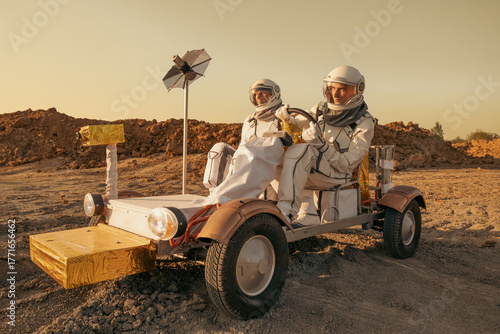 Astronaut crew navigating a rover across the rocky surface of Mars.
