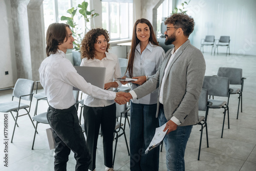 Doing handshake, deal. Group of people are working in the office together as a team