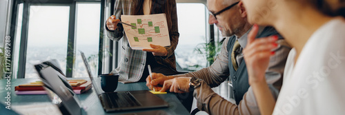 Papier peint A dedicated team engages in strategic talks while reviewing an innovative presen