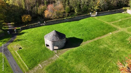 Aerial 4K drone footage showing a historic round stone building in Jenkinstown Wood and Walled Garden, Kilkenny, Ireland. Scenic view of green fields, heritage architecture, and peaceful countryside, 