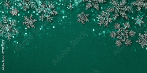 Glittering silver snowflakes frame the top border against a deep teal background with sparkling bokeh