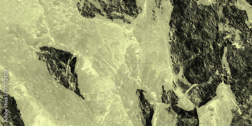 Abstract textured background with a pale yellow and dark gray color palette, featuring a granular speckled pattern and organic, irregular shapes that evoke a sense of weathered stone or aged