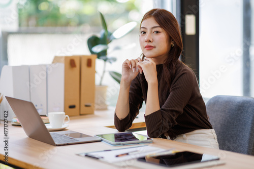 Concerned puzzled asian freelance worker woman looking at laptop with confused hand gesture. Frustrated worried computer user getting bad news, job technology failure, feeling shock, stress.
