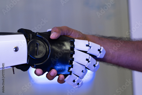 Human hand shaking with a robotic arm symbolizes partnership between humans and artificial intelligence. Concept of technology collaboration, future innovation, robotics, automation, and teamwork.
