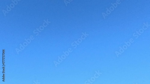Small handmade model airplane soars smoothly through bright blue sky with wings gliding under sunlight representing freedom creativity and childhood imagination