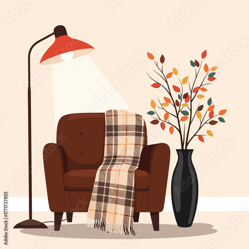 Cozy autumn reading nook with an armchair, plaid blanket, and fall foliage in a vase, creating a warm interior scene.