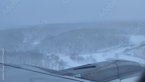plane landing in heavy snow winter day at sapporo new chitose airport in hokkaido airplane wing view video