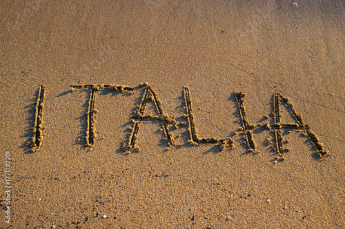 Fototapeta Naklejka Na Ścianę i Meble -  The word “Italia” written on the sand by the sea