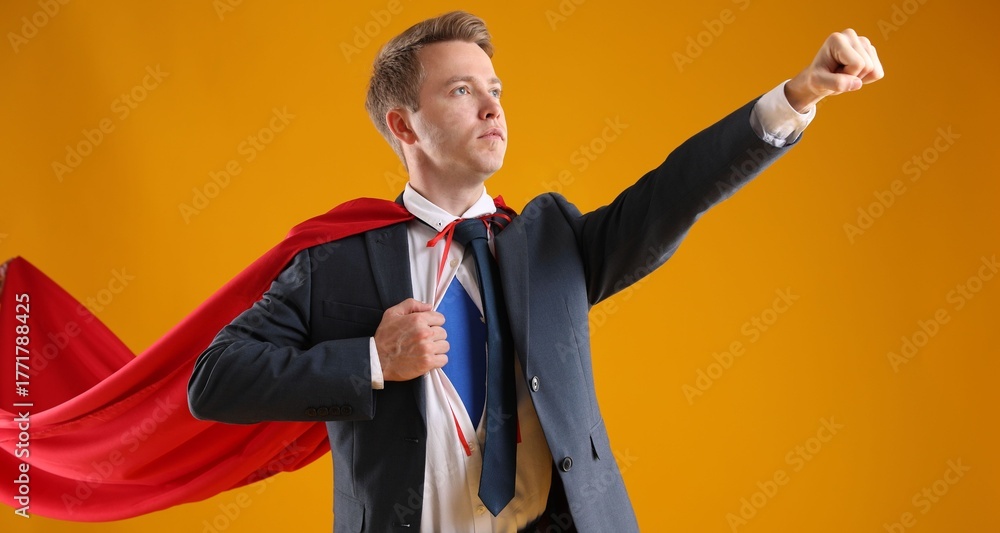 © New Africa - Businessman wearing superhero costume on yellow background © New Africa - Businessman wearing superhero costume on yellow background