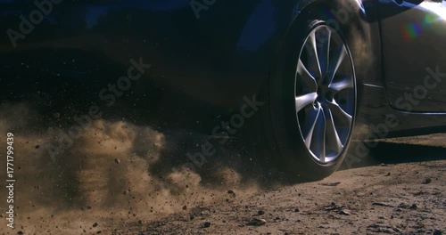 Slow motion of a car wheel spinning and kicking up dust on a dirt road. Dynamic slow-motion footage capturing power and movement a1000 fps.