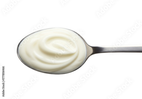 A metal spoon filled with creamy white yogurt or sour cream isolated on transparent background
