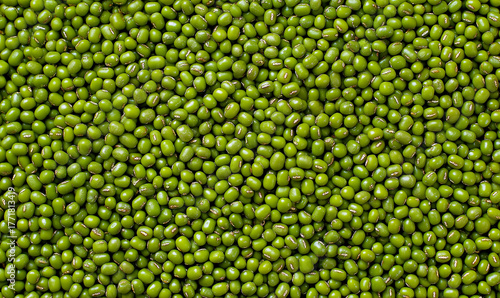 An overhead, full-frame close-up of a dense, uniform texture made entirely of bright green mung beans (moong dal).