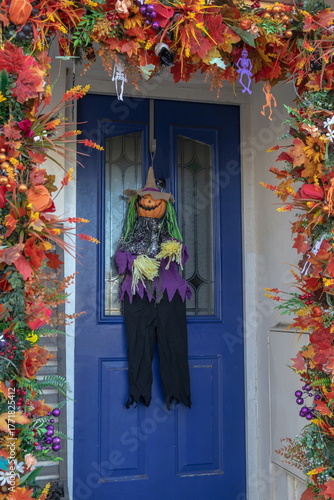 Scarecrow hanging in a front of the door during Halloween season 