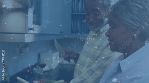 Senior couple using cooking recipe on tablet with animations as vegetables get chopped and sauteed