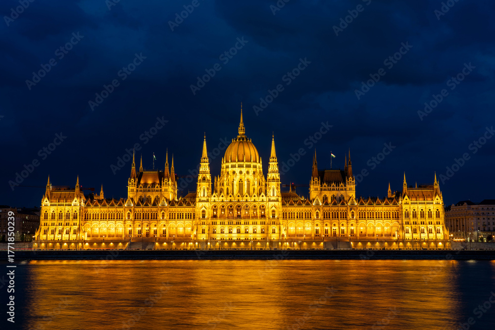 Fototapeta premium Budapest Parliament Building Illuminated at Night With the Danube River in Hungary
