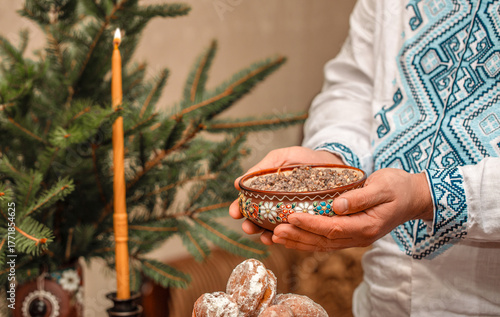 Traditional Ukrainian kutia served on Christmas Eve in ceramic bowl with embroidered shirt, festive ritual dish with wheat and poppy seeds, kutia for Holy Supper in authentic ethnic setting