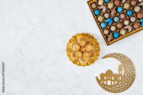    Traditional arabic Eid al Adha, Eid al Fitr , Ramadan sweets with golden moon decor. Colorful chocolate candy, semolina maamoul cookies with arabic coffee. Top view