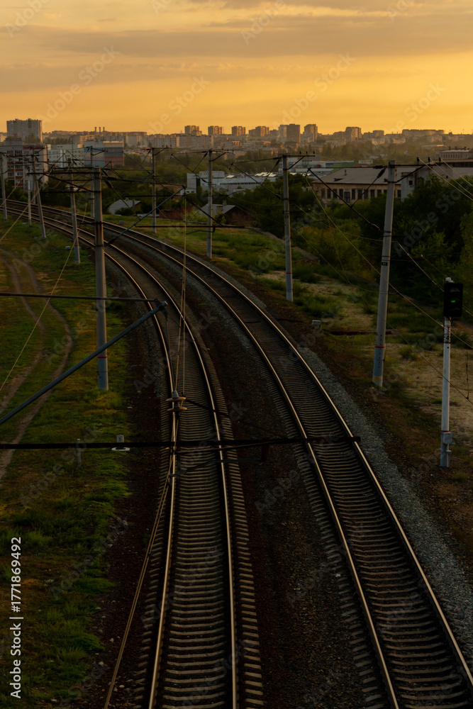 Fototapeta premium Sunset view of railway tracks winding through city landscape