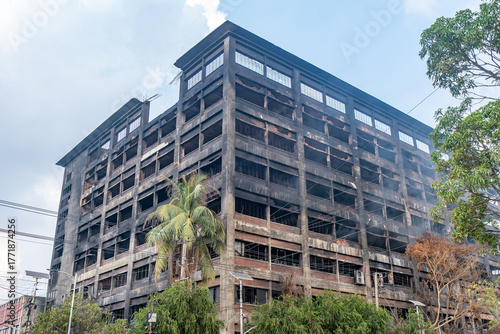 Fotografía Soot-covered building after a devastating fire, with smoke rising