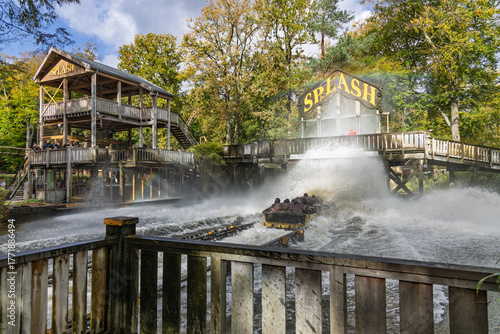 A log flume boat makes a massive, dramatic splashdown on the Duinrell Splash ride, soaking spectators and riders amid the rustic wooden structures. Wassenaar, Netherlands. 24 October 2025.
