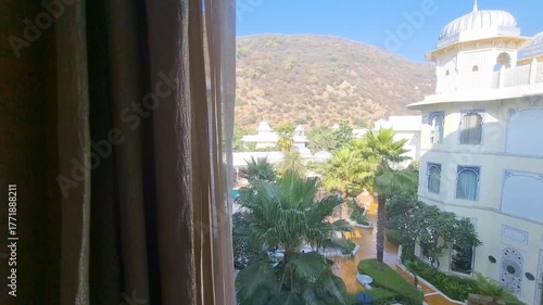 Looking out the window of a palace at the white buildings with domes, arches and gardens below showing the mughal, rajput architecture of Jaipur, Jodhpur, Udaipur, Jaisalmer