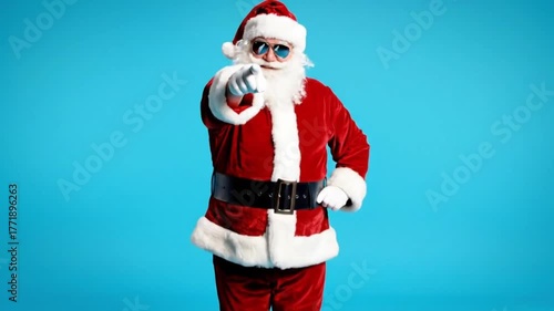 A man in Santa Claus costume with sunglasses points, winks, makes gestures and poses, representing holiday cheer, festive spirit, cool persona, modern Santa
