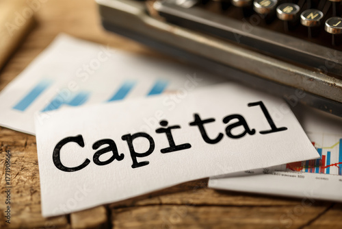 Typed word capital on paper with financial charts, symbolizing investment, business, and economic planning.
