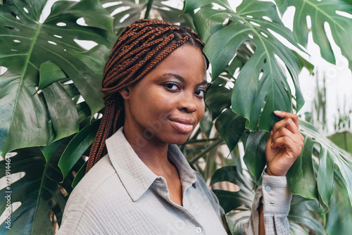 Portrait of a stylish African young woman among lush green foliage