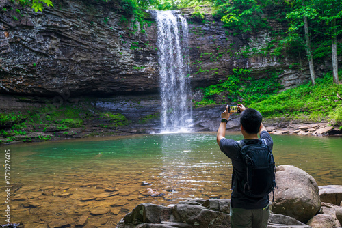 Εκτύπωση καμβά A man takes photo by phone while admiring majestic grandeur of Cherokee Falls in Cloudland Canyon State Park
