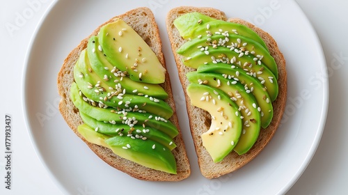 Top view of fresh avocado toast with sesame seeds on a white plate. Healthy vegetarian breakfast or brunch meal concept