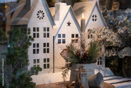 Christmas deco with house and candle light in a shopping window in December
