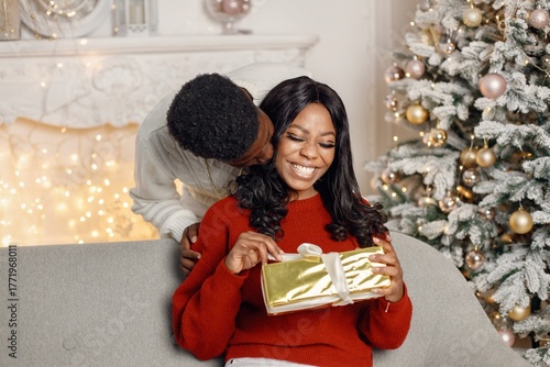 Young black man make a surprise for his girlfriend in Christmas eve