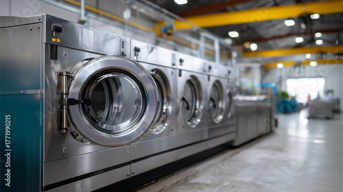 Industrial washing machines in modern commercial laundry facility. industrial laundry, washing machines, commercial laundry, laundry facility, stainless steel, cleaning equipment, textile care
