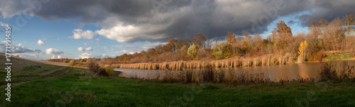 Autumn colors of a provincial region. A local pond and recreation area. A charming autumn landscape.