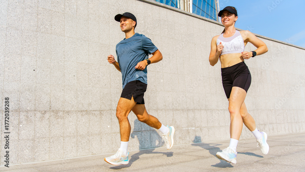 Fototapeta premium Marathon training session in an urban setting with runners staying fit together