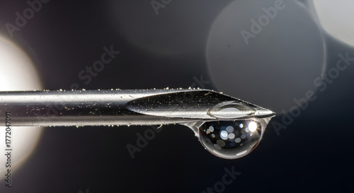 macro shot of hypodermic needle tip with liquid droplet