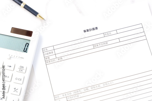 事業計画書 - 新規事業の立ち上げに先立ち、事業計画書を作成する起業家のイメージ
