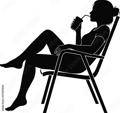 Silhouette of a woman relaxing in a deck chair drinking a beverage