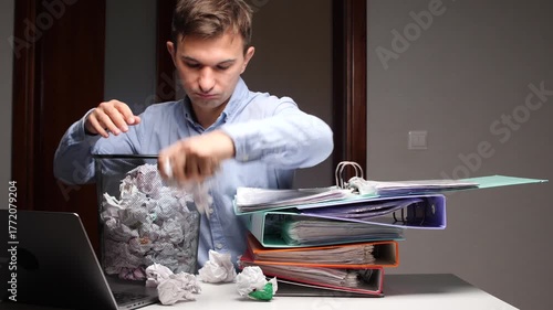 Office worker experiencing burnout throwing crumbled paper into bin