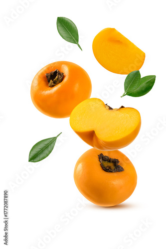 Falling persimmon fruits with cut in half and leaves isolated on white background.