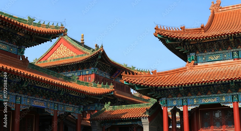 Naklejka premium Traditional Chinese architecture with ornate roofs and vibrant red, green, and gold detailing under blue sky