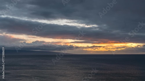 Timelapse of Dramatic sunset over the ocean with dark clouds.
