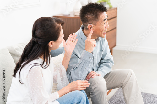 補聴器を付けた熟年男性と喜ぶ女性