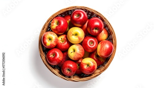 A wicker basket brimming with fresh red apples, some with yellow highlights, against a clean white backdrop, shot from an above-angle