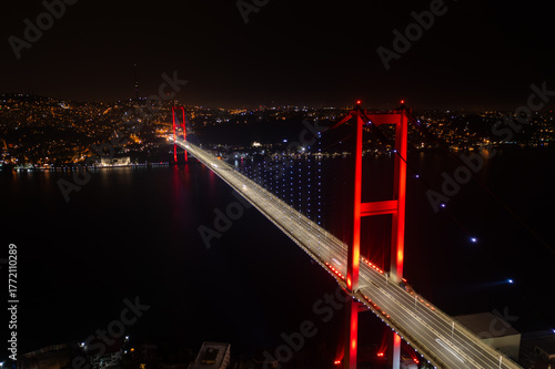 Aerial panoramic drone view of the 15 July Martyrs Bridge (Bosphorus Bridge) at night, connecting Europe and Asia in Istanbul, Turkey