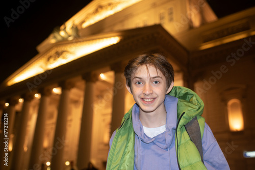 Teenage boy on an evening excursion around Moscow. Portrait of a child against the backdrop of the Bolshoi Theatre.	