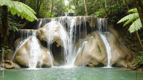 Majestic Waterfall Cascading Over Rocky Terraces Surrounded By Lush Green Ferns in Tropical Forest Serene Turquoise Pool Tranquil Nature Scenery