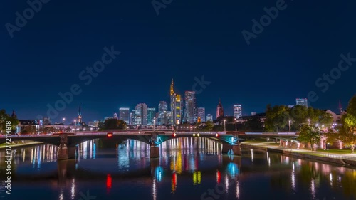 Timelapse of Frankfurt skyline at night with river and bridge.