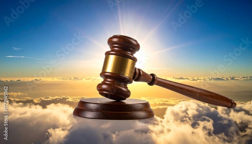 A wooden gavel rests atop clouds, with a vibrant sunset sky behind. Light beams emanate from where the sun would be, enhancing the scene
