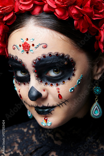 Halloween beauty close-up portrait of woman. Beautiful female face adorned with Santa Muerte makeup.